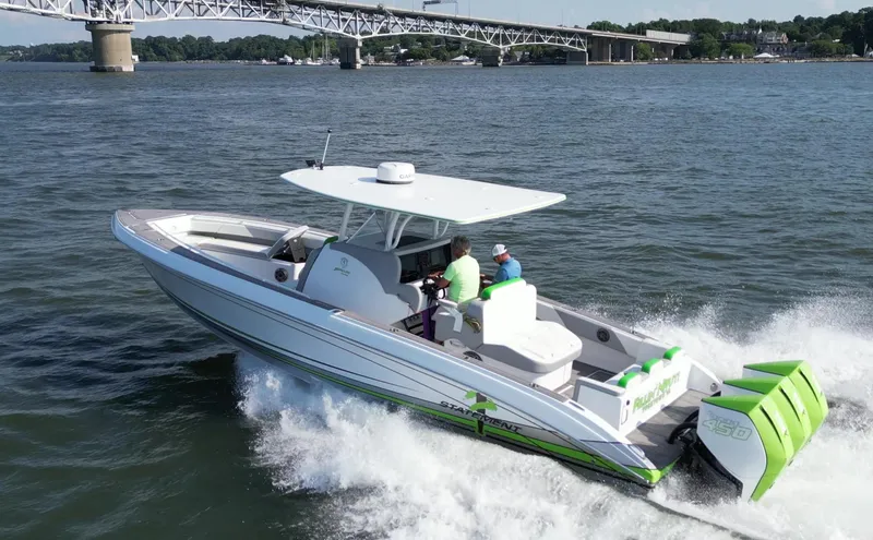  Yacht Photos Pics 2023 Statement 350 Open boat cruising on water near a bridge.