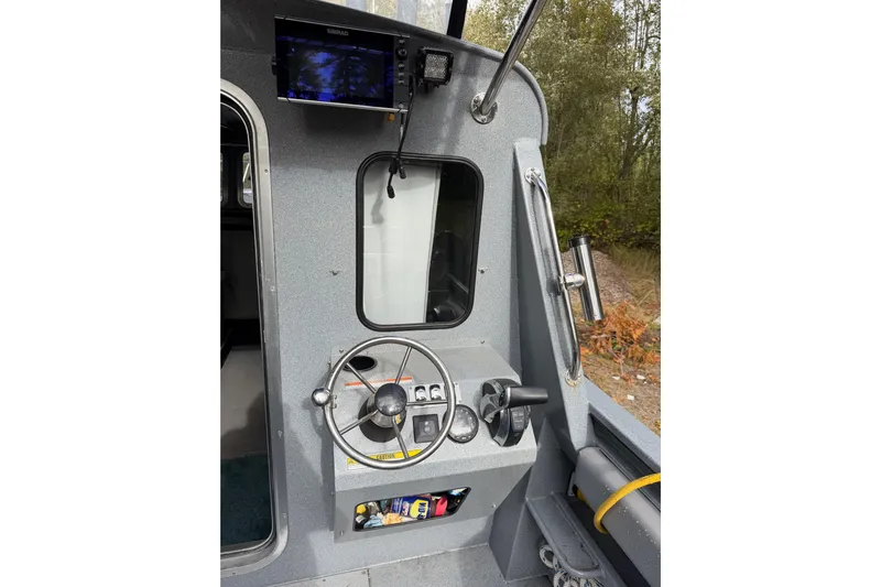  Yacht Photos Pics 2017 KingFisher 2825 Offshore boat helm with steering wheel and navigation equipment.