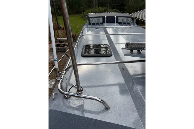  Yacht Photos Pics 2017 KingFisher 2825 Offshore boat deck with railing and hatch, surrounded by greenery.
