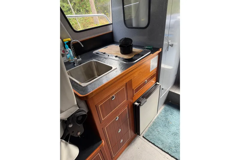  Yacht Photos Pics 2017 KingFisher 2825 Offshore boat interior with kitchenette, sink, and storage cabinets.