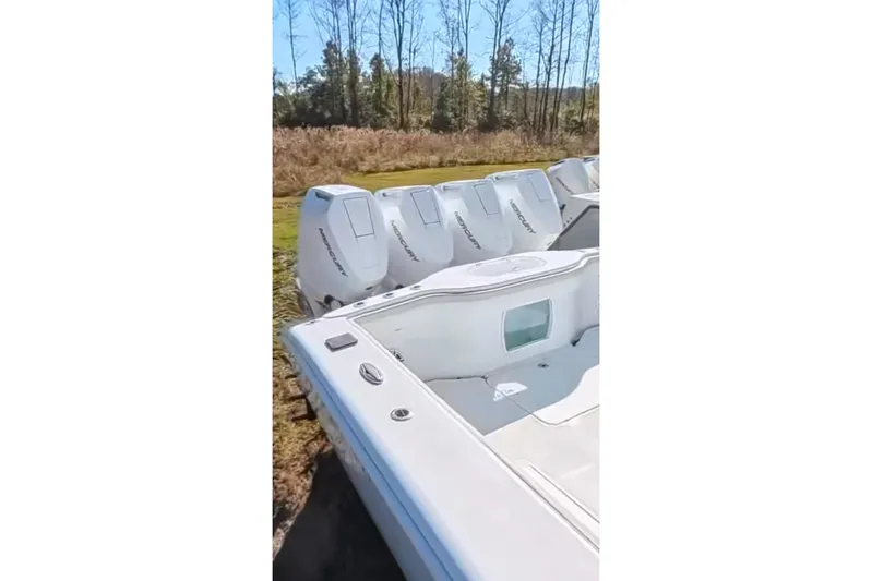 Fluid Mechanic Yacht Photos Pics 2024 Yellowfin 39 Offshore boat with multiple Mercury outboard engines, parked outdoors.