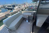 2019 Cranchi T36 Crossover yacht with elegant seating and table, docked at a marina.