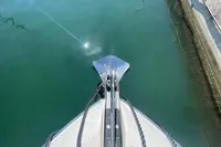 Bow of 2019 Cranchi T36 Crossover yacht with anchor, docked in calm water.