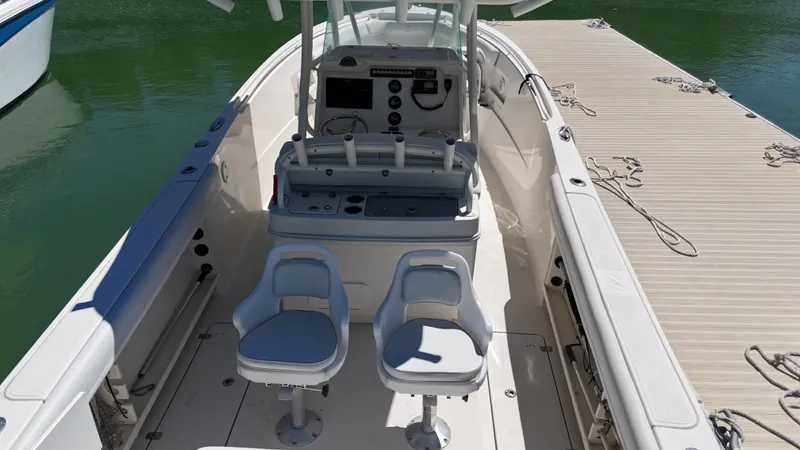  Yacht Photos Pics 2015 Sailfish 290cc boat interior with dual seats and control panel, docked by the water.