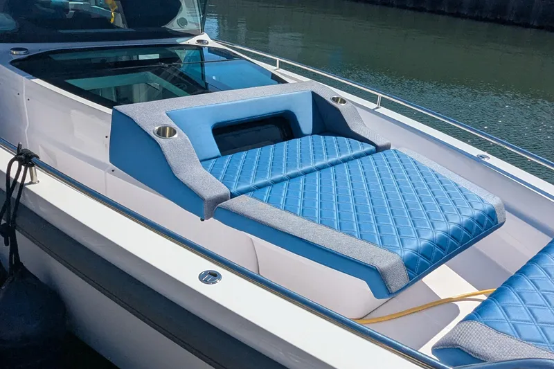 Nocellara De Belice Yacht Photos Pics 2024 Axopar 37 Cross Cabin with blue quilted bench seat, docked by water.
