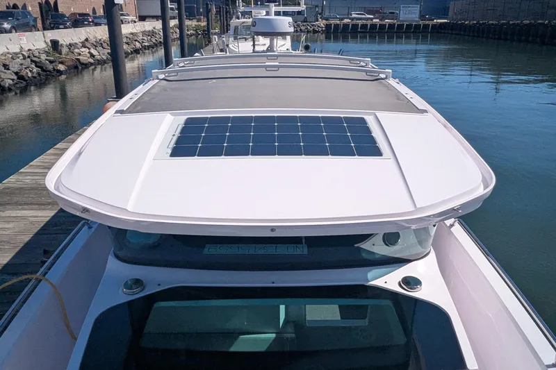 Nocellara De Belice Yacht Photos Pics 2024 Axopar 37 Cross Cabin with solar panel on roof, docked by the water.