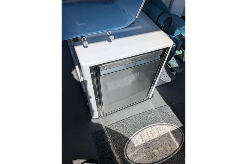 Nocellara De Belice Yacht Photos Pics 2024 Axopar 37 Cross Cabin interior with bench seat and compact fridge.