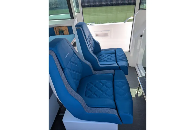 Nocellara De Belice Yacht Photos Pics 2024 Axopar 37 Cross Cabin interior with blue bench seats, modern design.