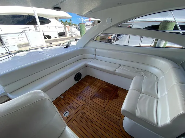  Yacht Photos Pics Luxurious seating area on a 2006 Pershing 50 yacht with white cushions and wooden flooring.