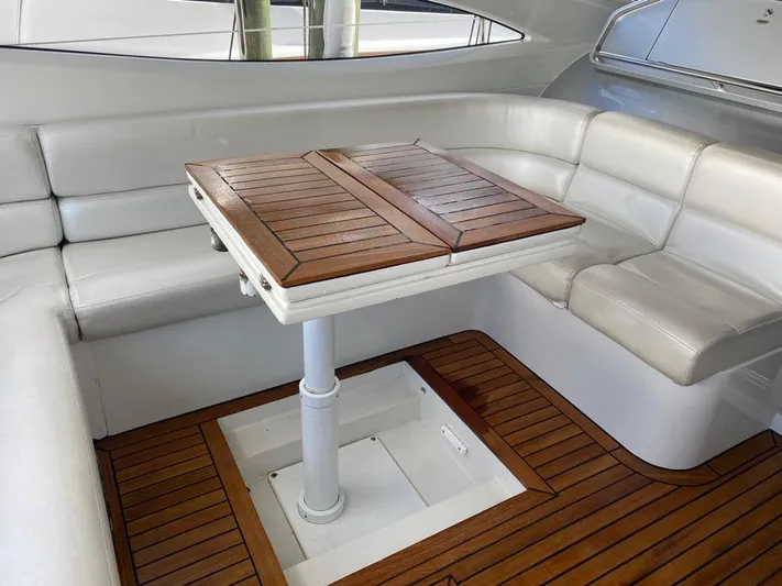  Yacht Photos Pics Luxurious interior of 2006 Pershing 50 yacht with white seating and wooden table.