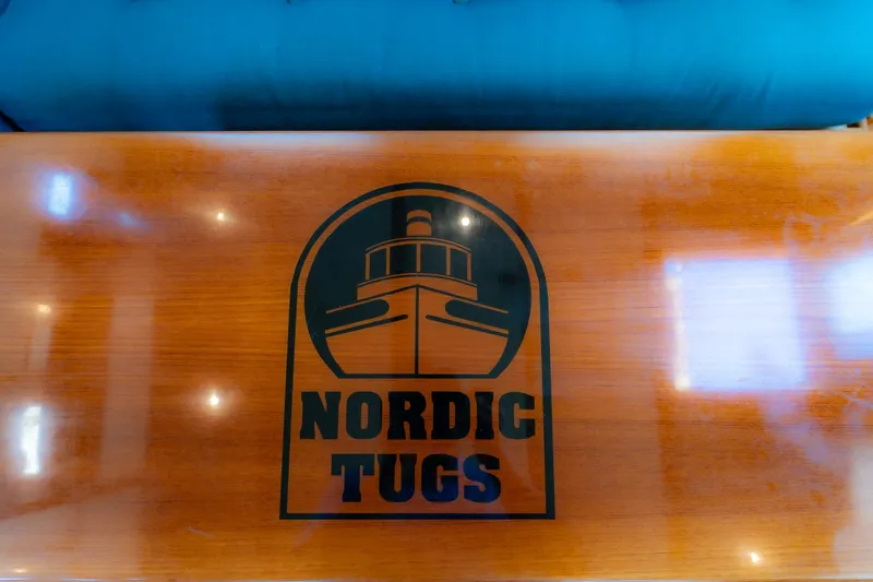 Cinnamon Girl Yacht Photos Pics Nordic Tug 32 logo on polished wooden surface, 2000 model.