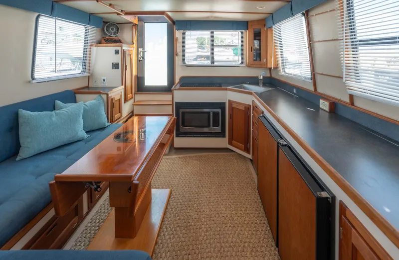 Cinnamon Girl Yacht Photos Pics Interior of 2000 Nordic Tug 32, featuring cozy seating, kitchenette, and ample natural light.