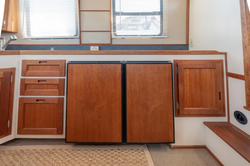 Cinnamon Girl Yacht Photos Pics Interior of a 2000 Nordic Tug 32, featuring wooden cabinetry and a compact kitchen area.