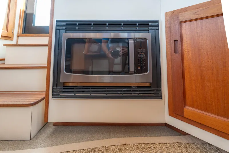 Cinnamon Girl Yacht Photos Pics Microwave oven in 2000 Nordic Tug 32 interior, near wooden stairs and cabinet.