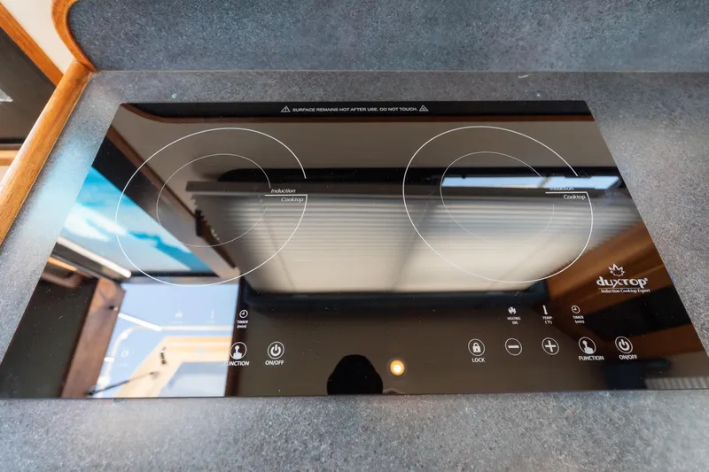 Cinnamon Girl Yacht Photos Pics Induction cooktop on 2000 Nordic Tug 32 boat, featuring sleek black design and touch controls.