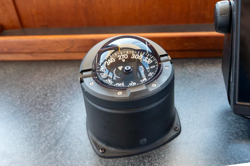 Cinnamon Girl Yacht Photos Pics Compass on a 2000 Nordic Tug 32 boat dashboard, displaying navigation directions.