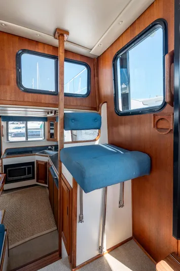 Cinnamon Girl Yacht Photos Pics Interior of 2000 Nordic Tug 32, featuring wood paneling and blue cushioned seating.