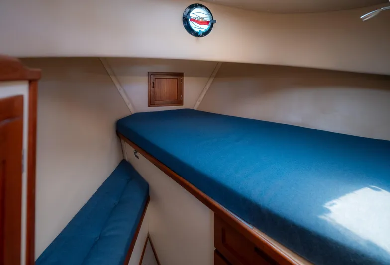Cinnamon Girl Yacht Photos Pics Cozy cabin interior of 2000 Nordic Tug 32 with blue bedding and wooden accents.
