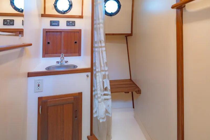 Cinnamon Girl Yacht Photos Pics Interior of a 2000 Nordic Tug 32, featuring a compact bathroom with sink and portholes.