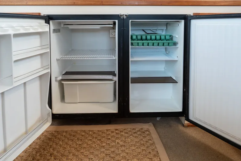 Cinnamon Girl Yacht Photos Pics Open refrigerator on Nordic Tug 32 boat, showing empty shelves and egg trays, 2000 model.