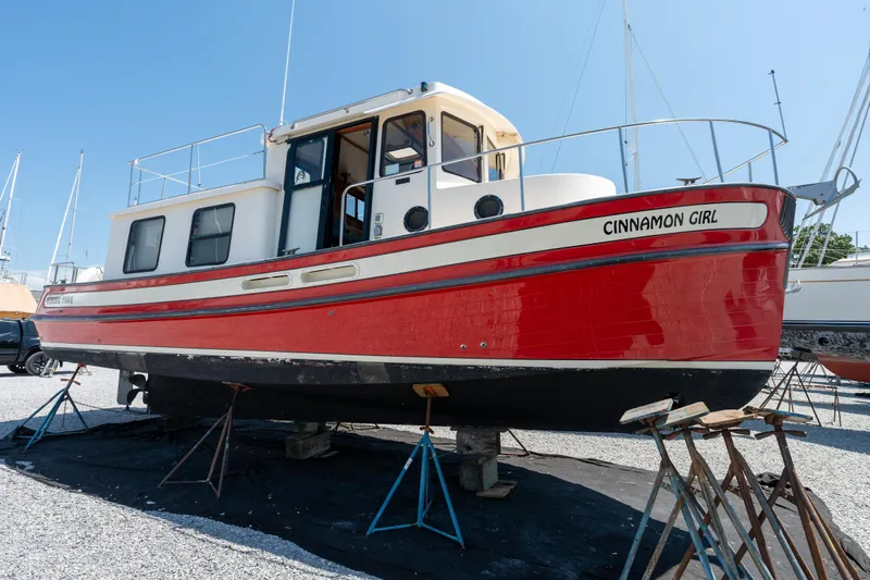 Cinnamon Girl Yacht Photos Pics Red 2000 Nordic Tug 32 boat named "Cinnamon Girl" on stands in a boatyard.
