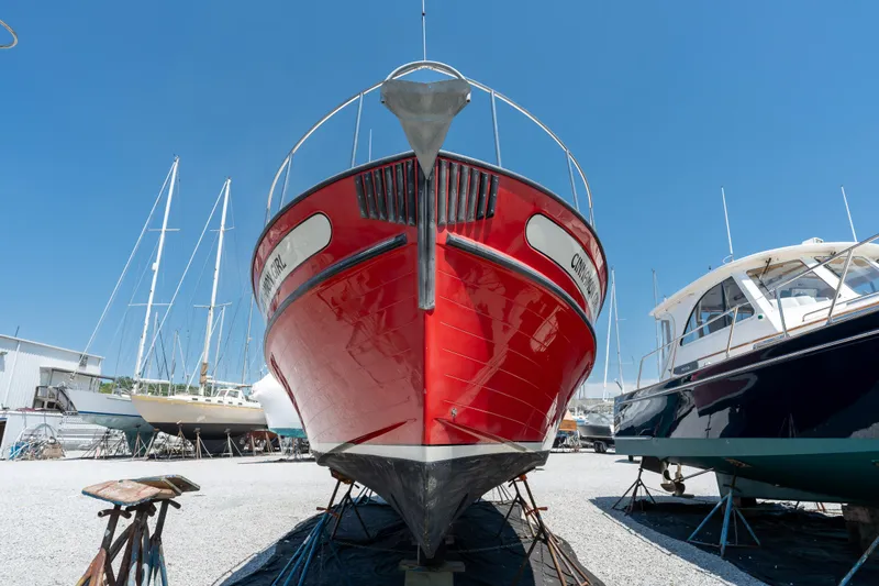 Cinnamon Girl Yacht Photos Pics Red 2000 Nordic Tug 32 boat on dry dock under clear blue sky.
