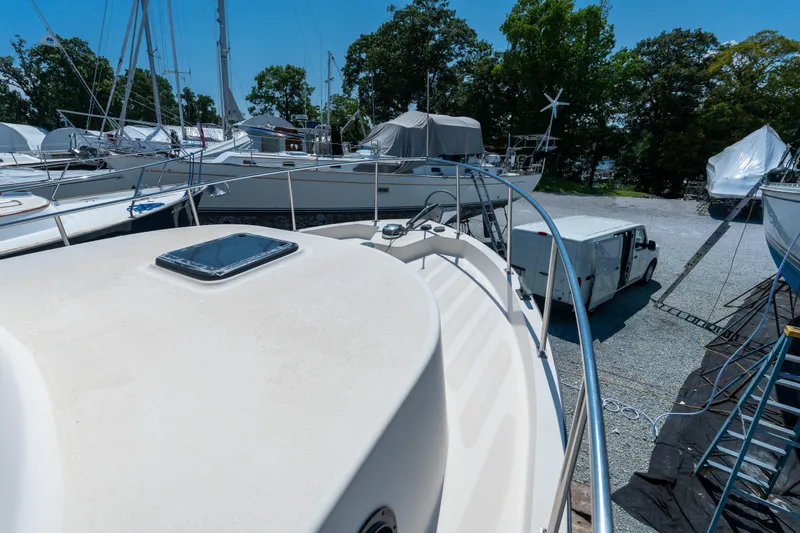 Cinnamon Girl Yacht Photos Pics Nordic Tug 32 (2000) on dry dock, surrounded by other boats and a white van.