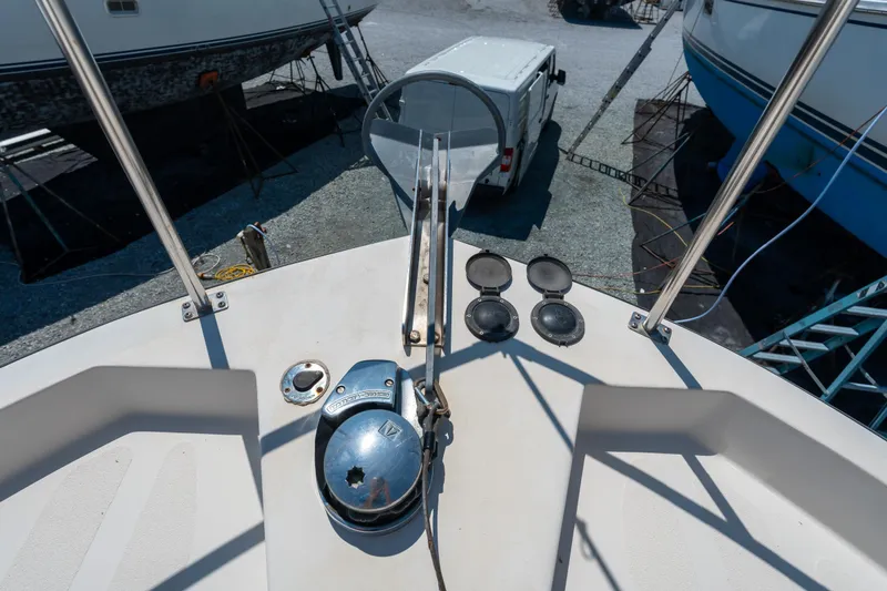 Cinnamon Girl Yacht Photos Pics Nordic Tug 32 (2000) bow deck with anchor winch and railing, in a boatyard.