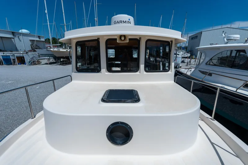 Cinnamon Girl Yacht Photos Pics Nordic Tug 32 boat, 2000 model, docked with Garmin equipment, surrounded by other vessels.