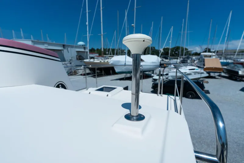 Cinnamon Girl Yacht Photos Pics Nordic Tug 32 (2000) on deck, marina background with multiple boats and clear blue sky.
