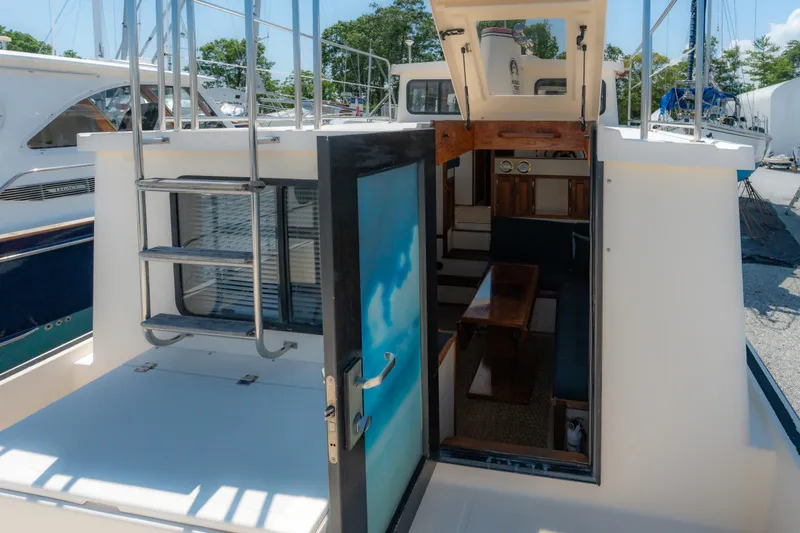 Cinnamon Girl Yacht Photos Pics Nordic Tug 32 (2000) interior view with open door and ladder, docked in marina.