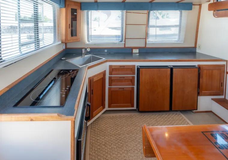 Cinnamon Girl Yacht Photos Pics Interior of 2000 Nordic Tug 32, featuring a modern kitchen with wood cabinetry.