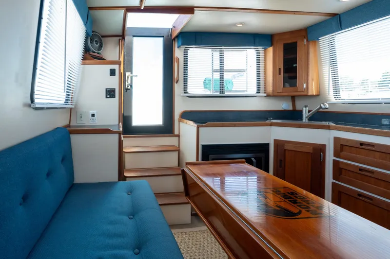 Cinnamon Girl Yacht Photos Pics Interior of a 2000 Nordic Tug 32, featuring a cozy seating area and compact kitchen.