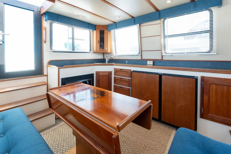 Cinnamon Girl Yacht Photos Pics Interior of a 2000 Nordic Tug 32, featuring wood cabinetry and a cozy seating area.