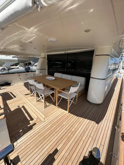  Yacht Photos Pics Outdoor dining area on 2010 Sanlorenzo SL82 yacht with wooden deck and modern furniture.
