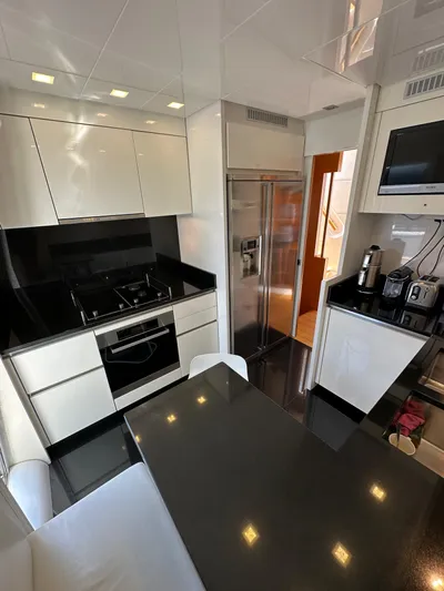  Yacht Photos Pics Modern kitchen interior of 2010 Sanlorenzo SL82 yacht with sleek appliances and black countertops.