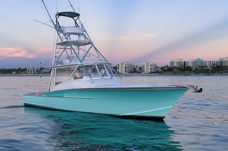 Karma Yacht Photos Pics 2019 Winter Custom Yachts 46 Walkaround on calm water at sunset, cityscape in background.
