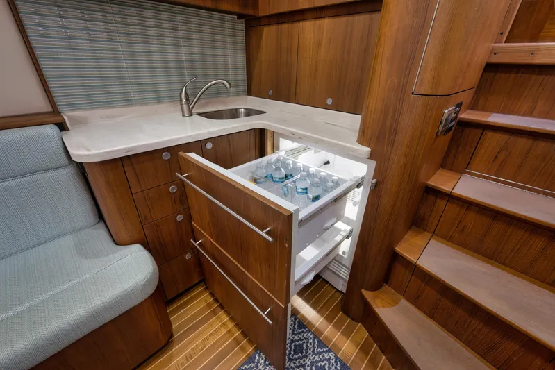 Karma Yacht Photos Pics Luxurious 2019 Winter Custom Yachts 46 Walkaround interior with wooden cabinetry and built-in fridge.