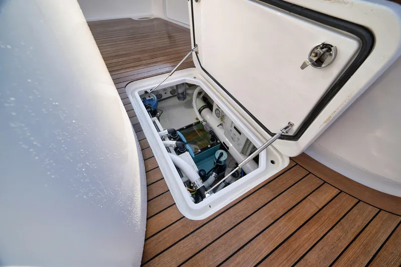 Karma Yacht Photos Pics Open hatch on 2019 Winter Custom Yachts 46 Walkaround, revealing mechanical components on teak deck.