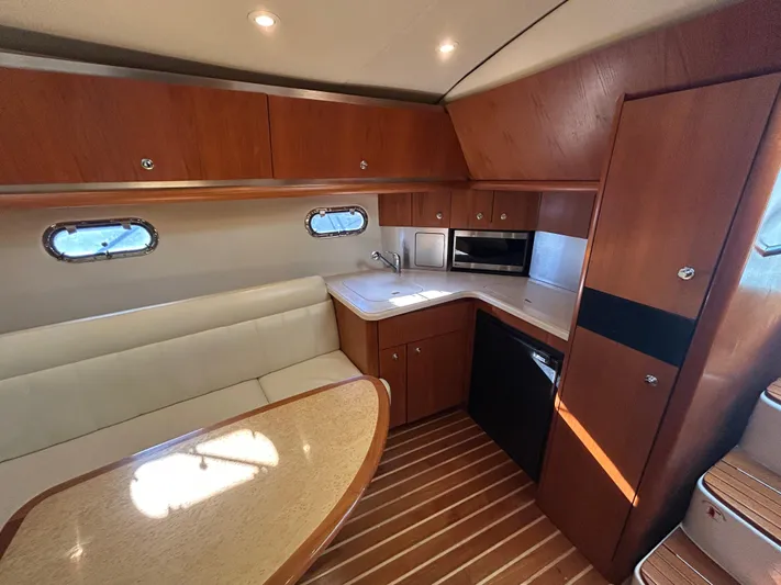  Yacht Photos Pics 2005 Tiara Yachts 3600 Sovran interior with wood cabinetry, seating, and kitchenette.