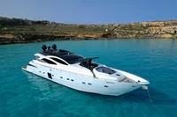 2008 Pershing 90 yacht anchored in clear turquoise waters near rocky coastline.
