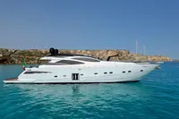 2008 Pershing 90 yacht on clear blue water with rocky coastline in the background.
