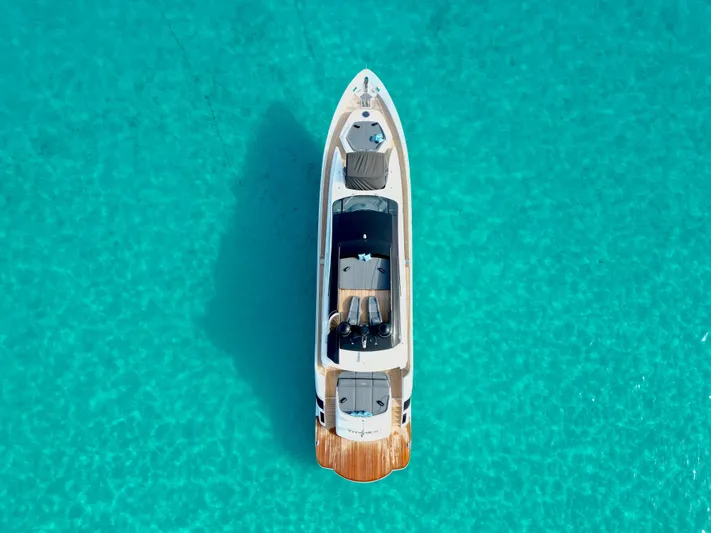 Thyke III Yacht Photos Pics Aerial view of 2008 Pershing 90 yacht on clear turquoise water.