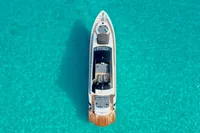Aerial view of 2008 Pershing 90 yacht on clear turquoise water.