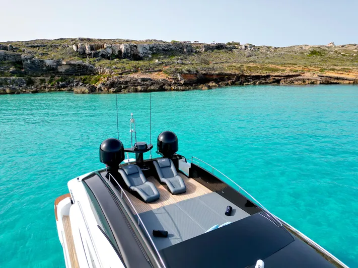 Thyke III Yacht Photos Pics 2008 Pershing 90 yacht on turquoise waters near rocky coastline.