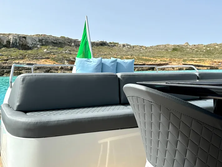 Thyke III Yacht Photos Pics Luxurious seating on a 2008 Pershing 90 yacht with scenic coastal view.