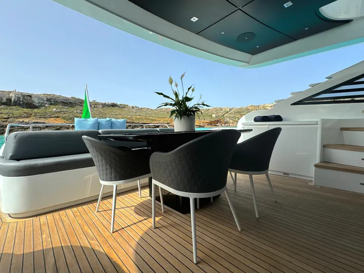 Thyke III Yacht Photos Pics Outdoor seating area on 2008 Pershing 90 yacht with modern chairs and table.