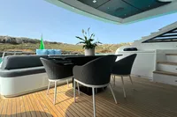 Outdoor seating area on 2008 Pershing 90 yacht with modern chairs and table.