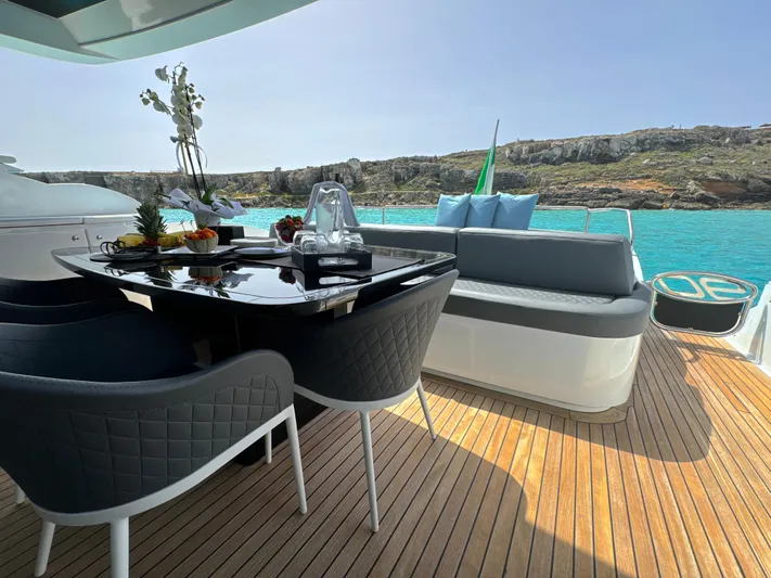 Thyke III Yacht Photos Pics Luxurious 2008 Pershing 90 yacht deck with elegant seating and dining area, overlooking turquoise waters.