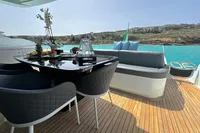 Luxurious 2008 Pershing 90 yacht deck with elegant seating and dining area, overlooking turquoise waters.